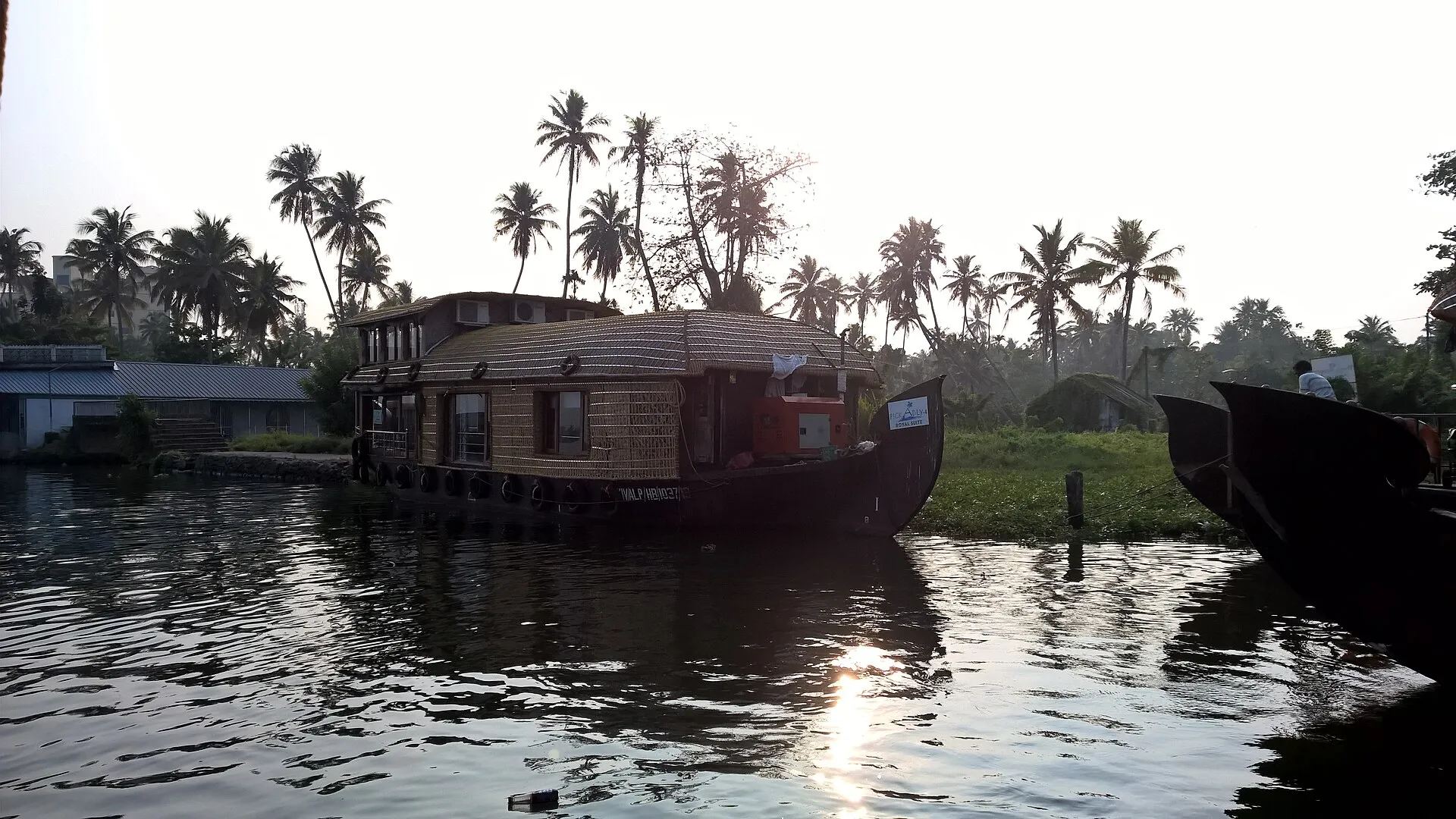 Sunset over the Kerala backwaters with a houseboat silhouette