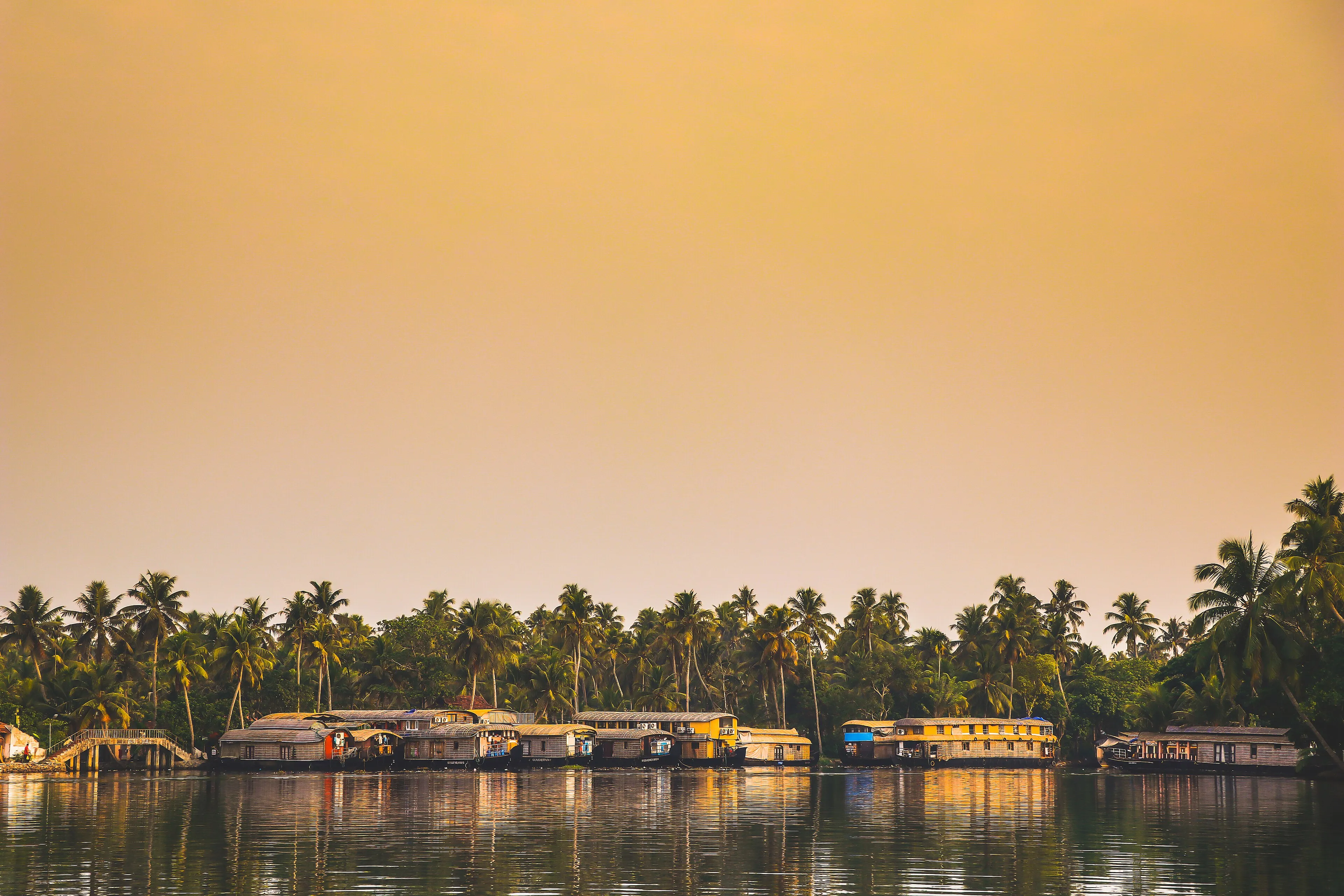 Kettuvallam houseboat cruising the palm-fringed Alleppey backwaters at golden hour in Kerala